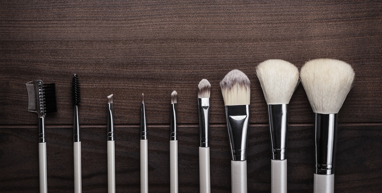 white make-up brushes on wooden background